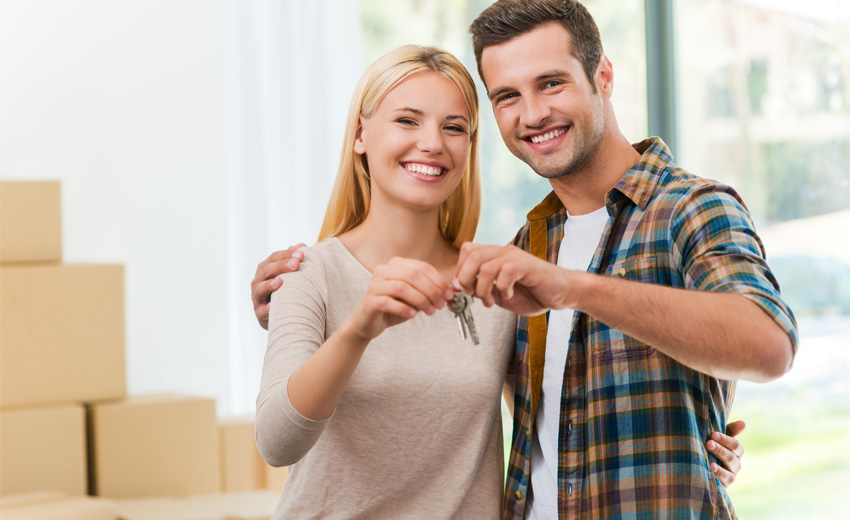 Strictly Conveyancing - a man and a woman holding keys to a newly-purchased home
